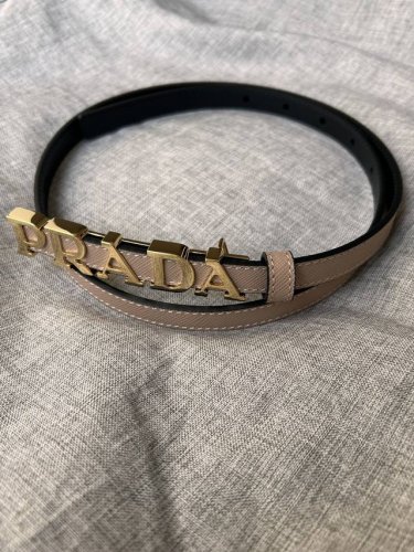 Prada 普拉达 专柜同款 女装休闲细腰带 宽 1.5Cm 这款采用saffiano原版皮内衬光滑小牛皮，搭配prada字母五金扣，可搭配不同风格的服装。原单