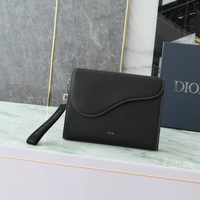 这款 A5 三角手拿包是 Dior 的全新主打单品。采用黑色粒面皮革等材质精心制作，搭配马鞍廓形翻盖，宽敞的拉链隔层可收纳手机，另外还设有卡槽。搭配可拆卸的腕带
