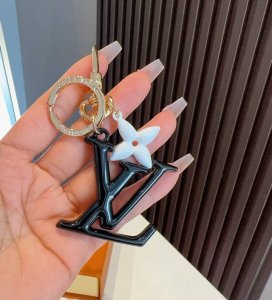 Lv钥匙扣珐琅工艺Lv字母挂件 Pop Flower包和钥匙扣的魅力非常适合为皮革配饰增添标志性的色彩，其特点是金色金属钩环，点缀着充满活力的Lv首字母和会标花