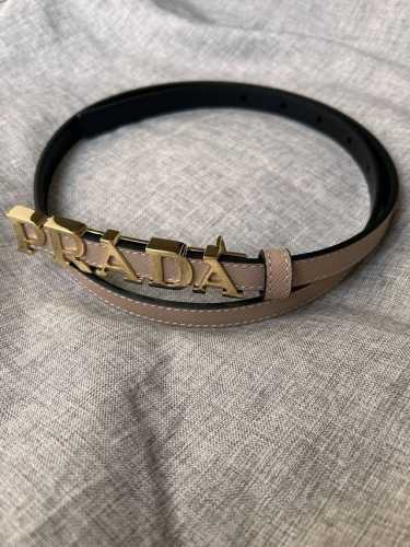 Prada 普拉达 专柜同款 女装休闲细腰带 宽 1.5Cm 这款采用saffiano原版皮内衬光滑小牛皮，搭配prada字母五金扣，可搭配不同风格的服装。原单