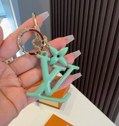Lv钥匙扣珐琅工艺Lv字母挂件 Pop Flower包和钥匙扣的魅力非常适合为皮革配饰增添标志性的色彩，其特点是金色金属钩环，点缀着充满活力的Lv首字母和会标花