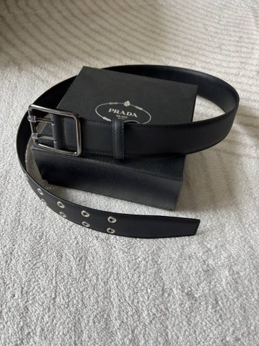 prada 普拉达 男款时尚皮带，4.0光滑头层黑色牛皮搭配利落金属针扣，孔眼设计别具一格。简约中透着精致，质感上乘，勾勒每一身时尚造型，轻松解锁高级氛围感。