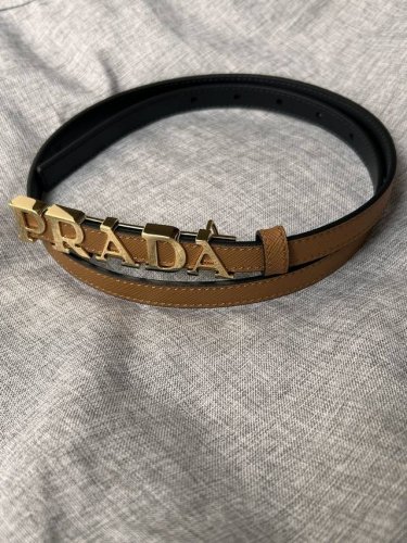 Prada 普拉达 专柜同款 女装休闲细腰带 宽 1.5Cm 这款采用saffiano原版皮内衬光滑小牛皮，搭配prada字母五金扣，可搭配不同风格的服装。原单