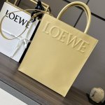 L家油亮Standard A4 Tote手袋 采用底部信封结构，可通过顶部提手或可拆卸肩带携带，这个大号版本采用 油亮牛皮革制成，正面饰有徽章压纹，内衬人字纹棉