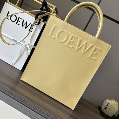 L家油亮Standard A4 Tote手袋 采用底部信封结构，可通过顶部提手或可拆卸肩带携带，这个大号版本采用 油亮牛皮革制成，正面饰有徽章压纹，内衬人字纹棉