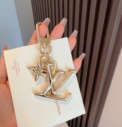 Lv钥匙扣珐琅工艺Lv字母挂件 Pop Flower包和钥匙扣的魅力非常适合为皮革配饰增添标志性的色彩，其特点是金色金属钩环，点缀着充满活力的Lv首字母和会标花