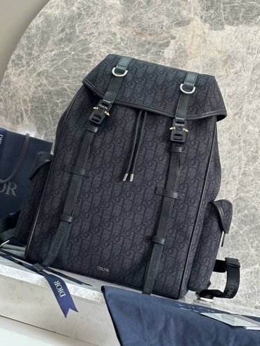 这款 Dior Hit The Road 翻盖双肩背包将现代风格与 Dior 的高订精神融为一体。采用黑色 Oblique 印花面料等材质精心制作，饰以同色调粒