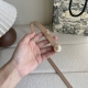 Dior新款腰带采用光滑牛皮材质精心制作，搭配富有光泽的珍珠饰面金属腰带扣，彰显优雅线条，并镌刻以Cd标志点缀，经典优雅，可与牛仔裤、半身裙或连衣裙轻松搭配。宽