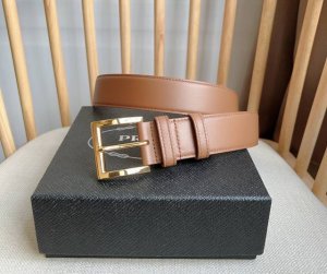 Prada 普拉达 专柜最新款 这款皮革腰带的尖部饰以标志性的涂珐琅金属三角形徽标 此徽标由mario Prada设计而来 1913年初次亮相于品牌的旅行箱 男