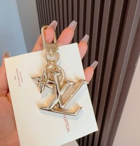 Lv钥匙扣珐琅工艺Lv字母挂件 Pop Flower包和钥匙扣的魅力非常适合为皮革配饰增添标志性的色彩，其特点是金色金属钩环，点缀着充满活力的Lv首字母和会标花