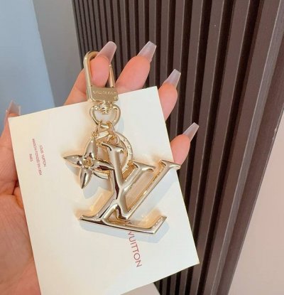 Lv钥匙扣珐琅工艺Lv字母挂件 Pop Flower包和钥匙扣的魅力非常适合为皮革配饰增添标志性的色彩，其特点是金色金属钩环，点缀着充满活力的Lv首字母和会标花