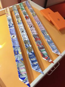 Phms2162 爱马仕 女骑士之舞 Twilly小丝巾 结合神话情节与当代风格。一位年轻女子的身体半掩在屏风后，好似屏风上彩绘“女骑士队伍 中的一员。在这古色